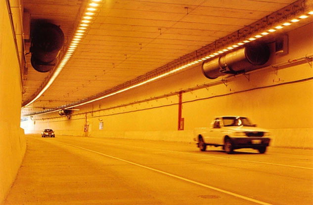 A white pickup drives through an underground tunnel.