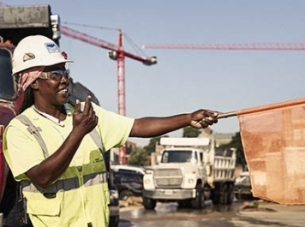 A woman directs traffic on a busy jobsite.