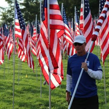 A person carrying a U.S. flag.