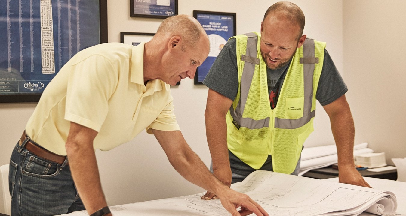 two people looking at plans in the office