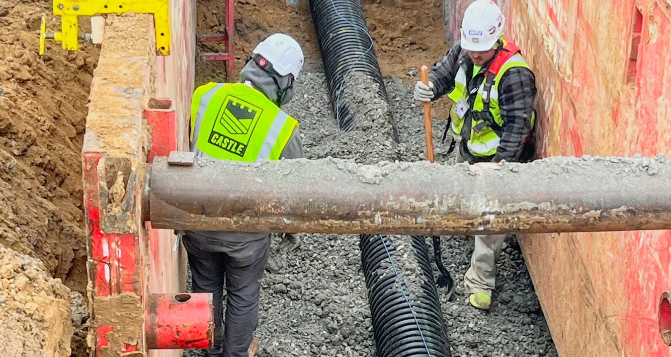 Two construction workers in boring pit
