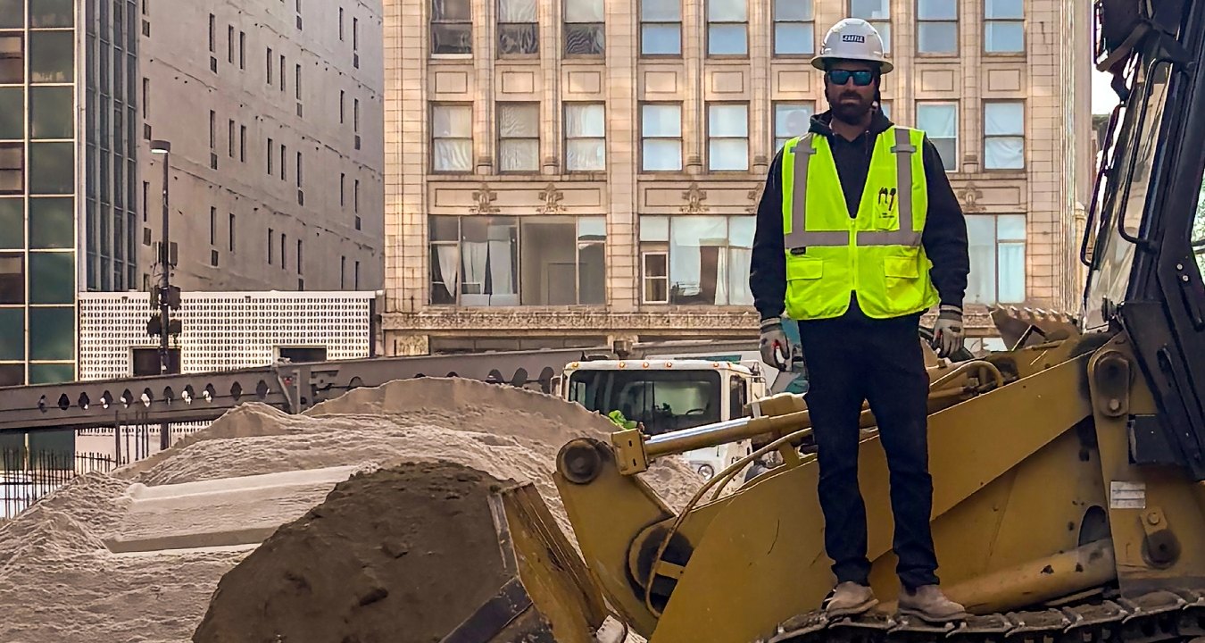 Brent Aden in PPE standing on dozer track system