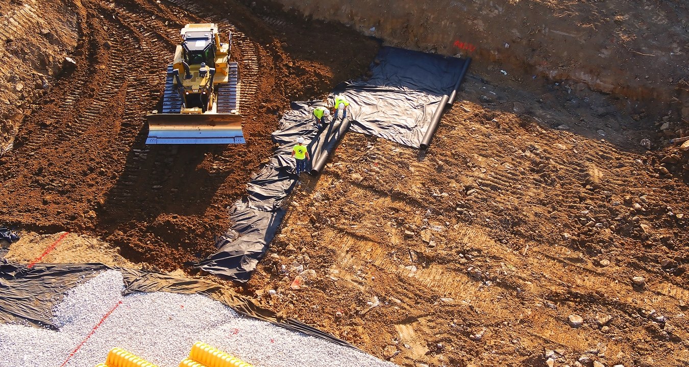 Dozer moving dirt in partially built detention pond