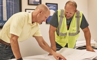 two people looking at plans in the office