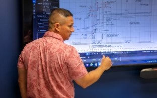 person looking over blueprints on tv