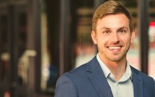 Portrait image of smiling Alex Fesi in office