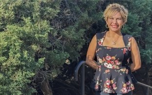 Abigail Garcia standing outside with green foliage background