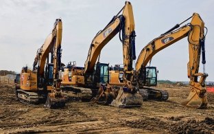 Three CAT excavators lined up on project site