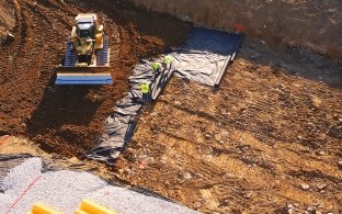 Dozer moving dirt in partially built detention pond