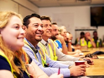 Smiling construction employees sitting at conference table
