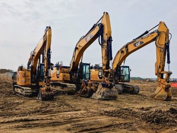 Three CAT excavators lined up on project site