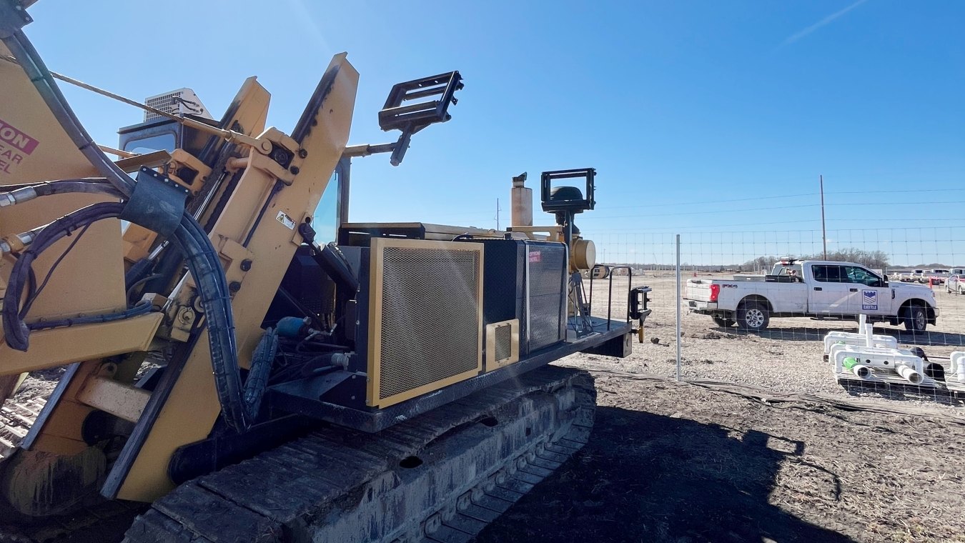 Jobsite setting paddle trencher foreground and Castle Contracting truck background 