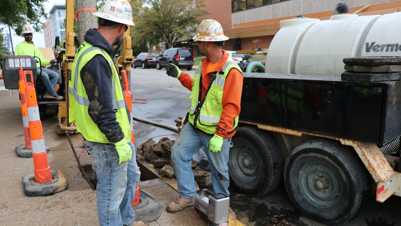 Two construction workers in PPE next to directional boring machine