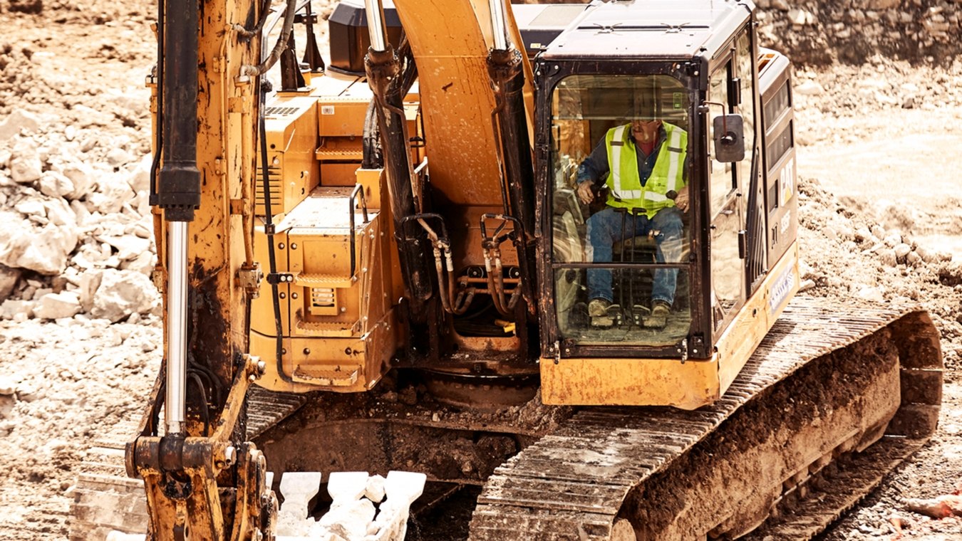 Construction worker operating CAT excavator close-up