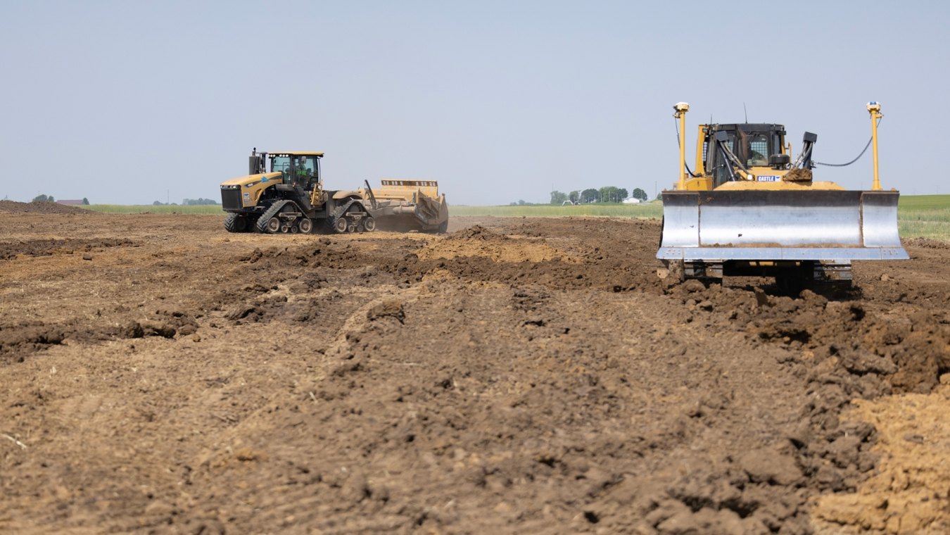 Scraper in background and excavator in foreground operating on jobsite