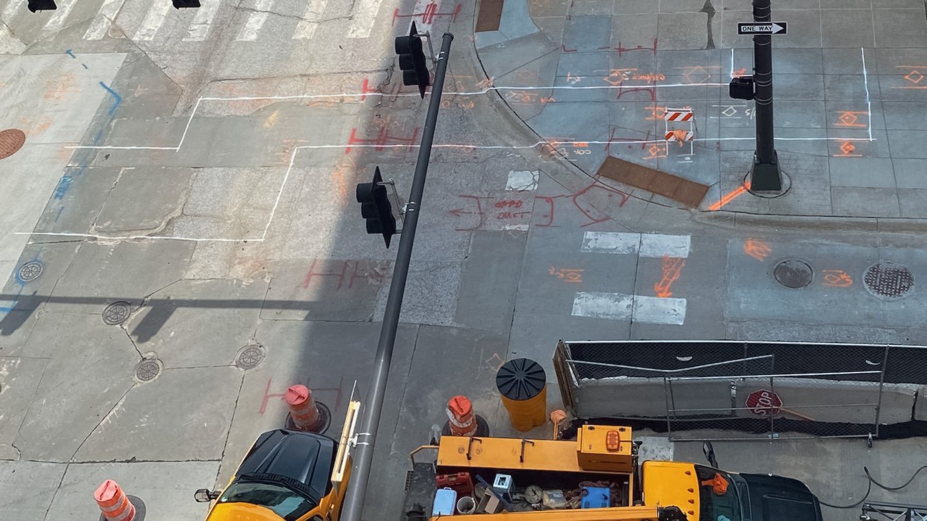 Work trucks at city street intersection with painted construction markers