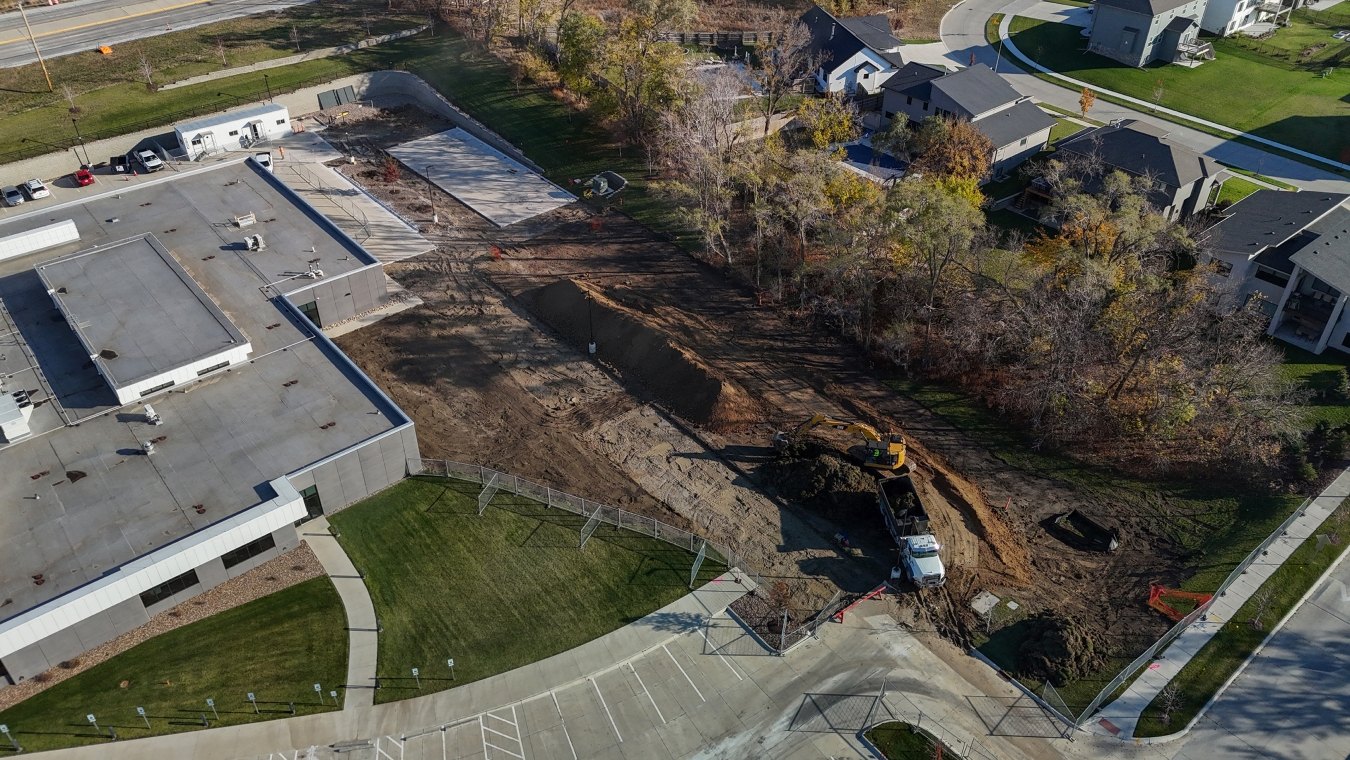 Arial drone shot of excavator, hauling truck, and earthwork