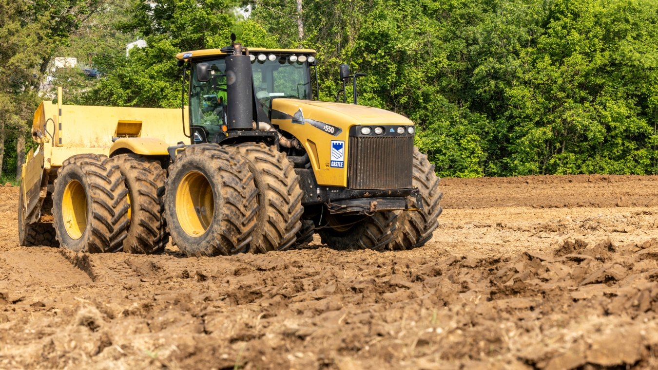 Yellow heavy construction equipment tractor and scraper