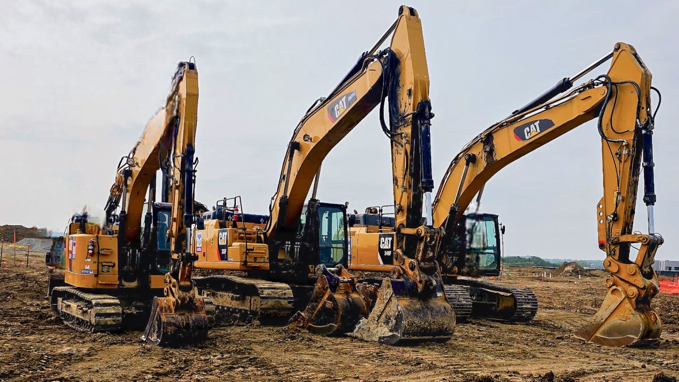 Three CAT excavators lined up on project site
