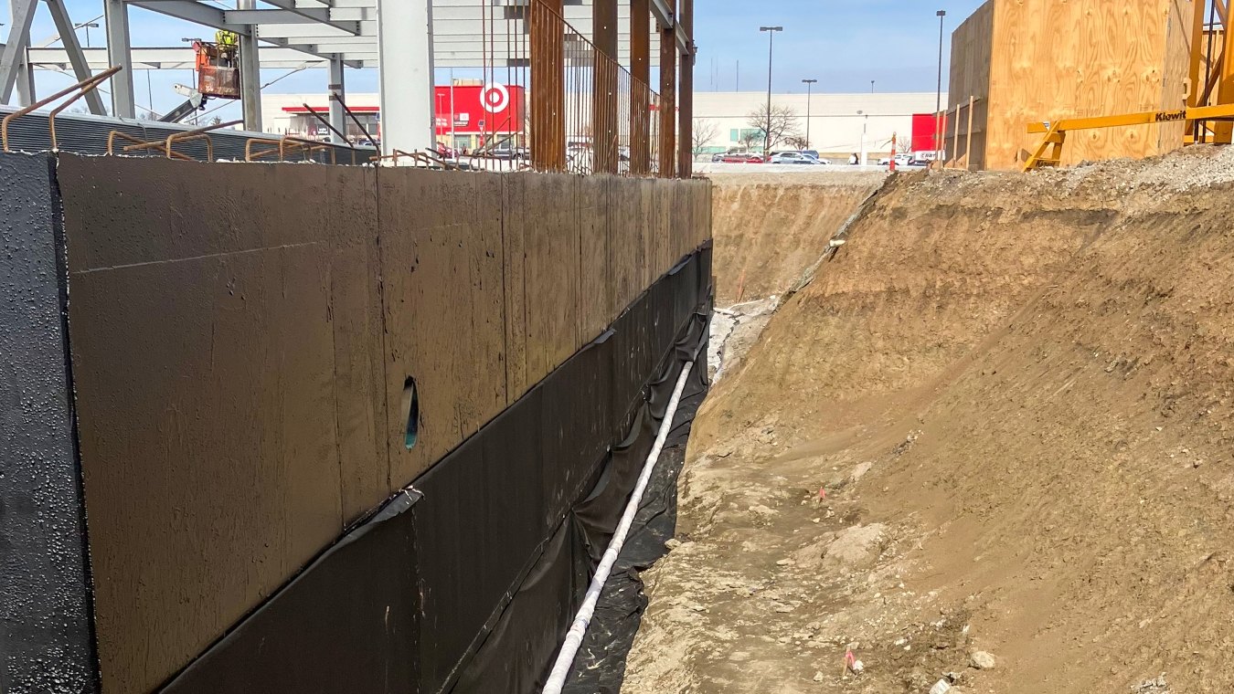 Constructed black foundation wall view at base of pit