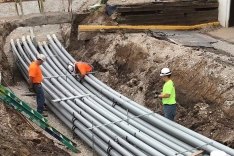 Construction workers laying pipe on a jobsite.