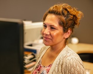 person smiling at computer screen