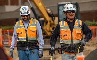 Two people walking and smiling on a jobsite