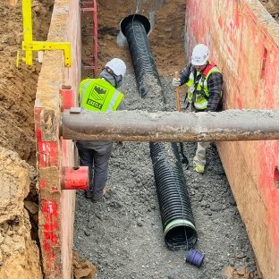 Two construction workers in boring pit