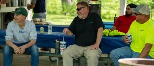 people sitting on picnic tables having a good laugh