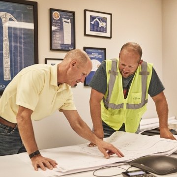 two people looking at plans in the office