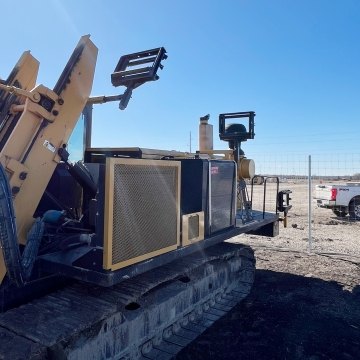 Jobsite setting paddle trencher foreground and Castle Contracting truck background 