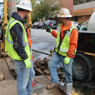 Two construction workers in PPE next to directional boring machine