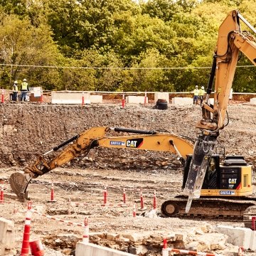 Yellow CAT excavator and GC Hammer operating on jobsite