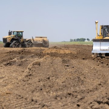 Scraper in background and excavator in foreground operating on jobsite