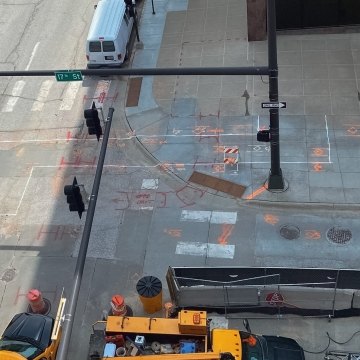 Work trucks at city street intersection with painted construction markers