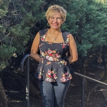 Abigail Garcia standing outside with green foliage background