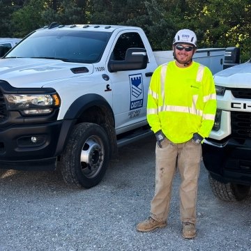 Smiling Tim Leonhardt in Full PPE standing next Castle Contracting truck