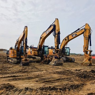 Three CAT excavators lined up on project site