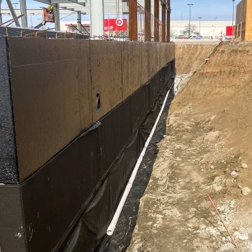 Constructed black foundation wall view at base of pit