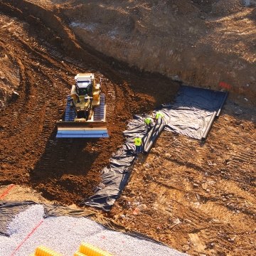 Dozer moving dirt in partially built detention pond